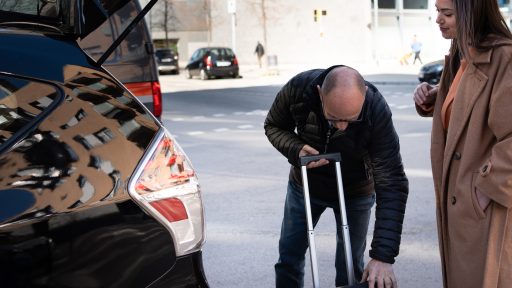 Taxi driver with public liability insurance holding luggage